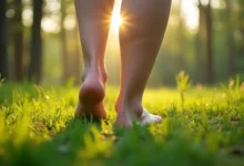 Person standing barefoot on grass in a peaceful forest practicing grounding techniques for anxiety relief